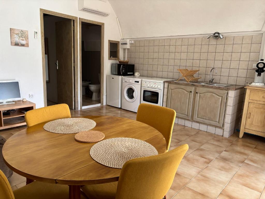 FelicetoにあるA volta appartement à la nuitée, linge comprisのテーブルと椅子のあるキッチンとダイニングルーム