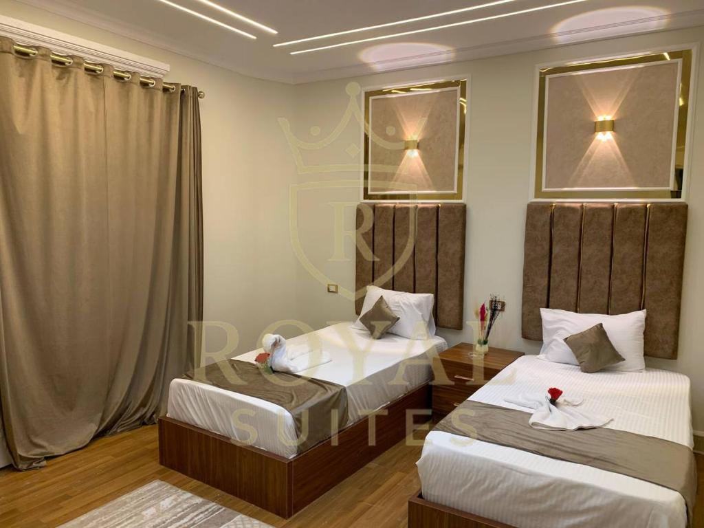 ein Schlafzimmer mit zwei Betten und einem Spiegel in der Unterkunft Downtown Royal Suites in Kairo