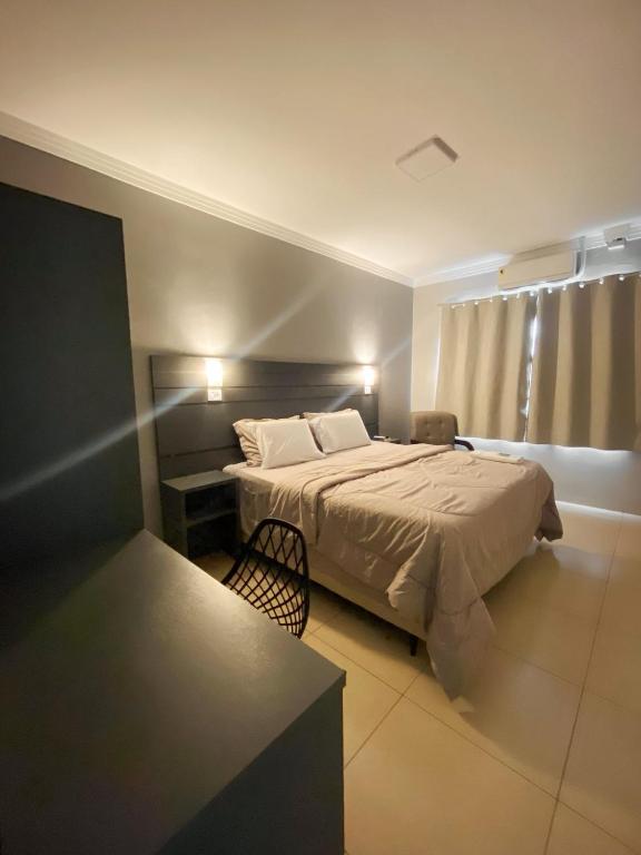 a bedroom with a bed and a chair in it at Euro Hotel in Ubiratã