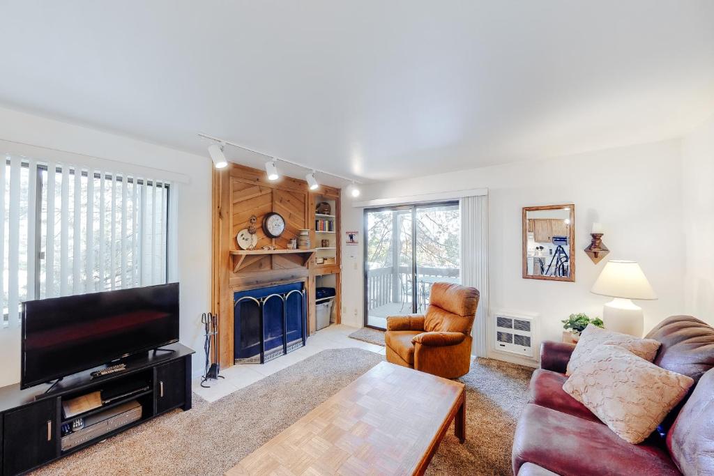 een woonkamer met een bank en een tv bij Red Pine N1 in Park West Ski Area Heliport
