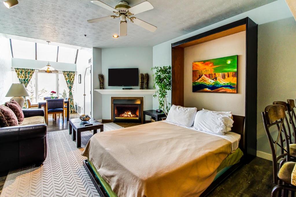 1 dormitorio con 1 cama y sala de estar con chimenea en Studio at The Lodge at Mountain Village, en Park City