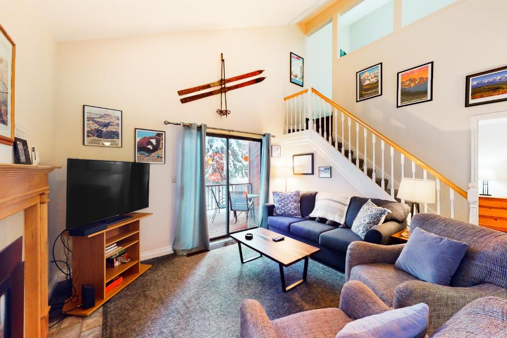 een woonkamer met een bank en een tv bij Red Pine Condos Unit #A7 in Park West Ski Area Heliport
