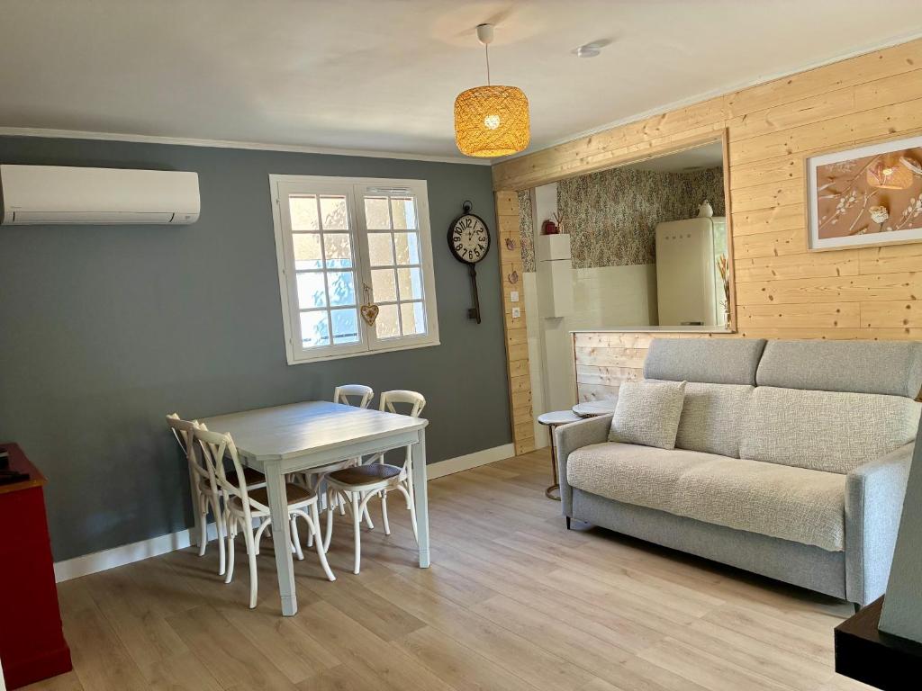 a living room with a table and a couch at La villa Les Rosiers en Cévennes in Saint-Martial