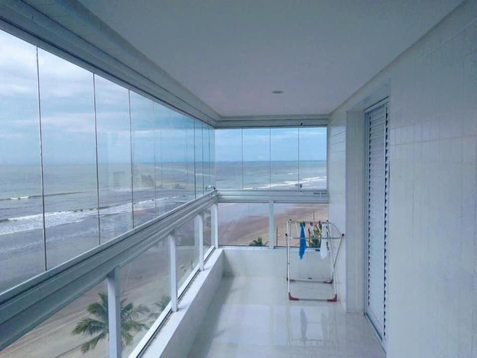 a room with a balcony with a view of the beach at Residencial Copacabana in Mongaguá