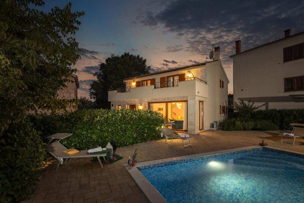 a house with a swimming pool in front of a house at Villa Mare With Private Pool And Garden - Happy Rentals in Malinska