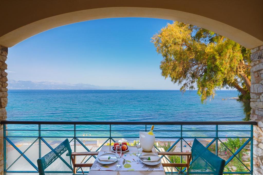 a table with a view of the ocean from a balcony at Grekis Beach Hotel and Apartments in Petalidi