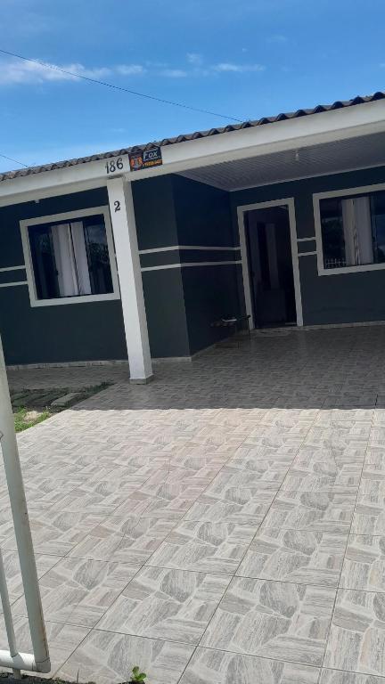 a blue building with a patio in front of it at Casa 3 quartos in Pontal do Paraná