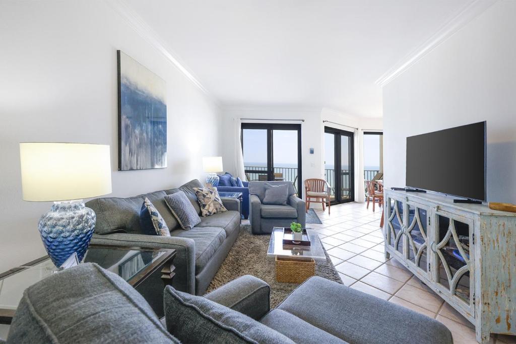 a living room with couches and a flat screen tv at Phoenix VI 61507 in Orange Beach
