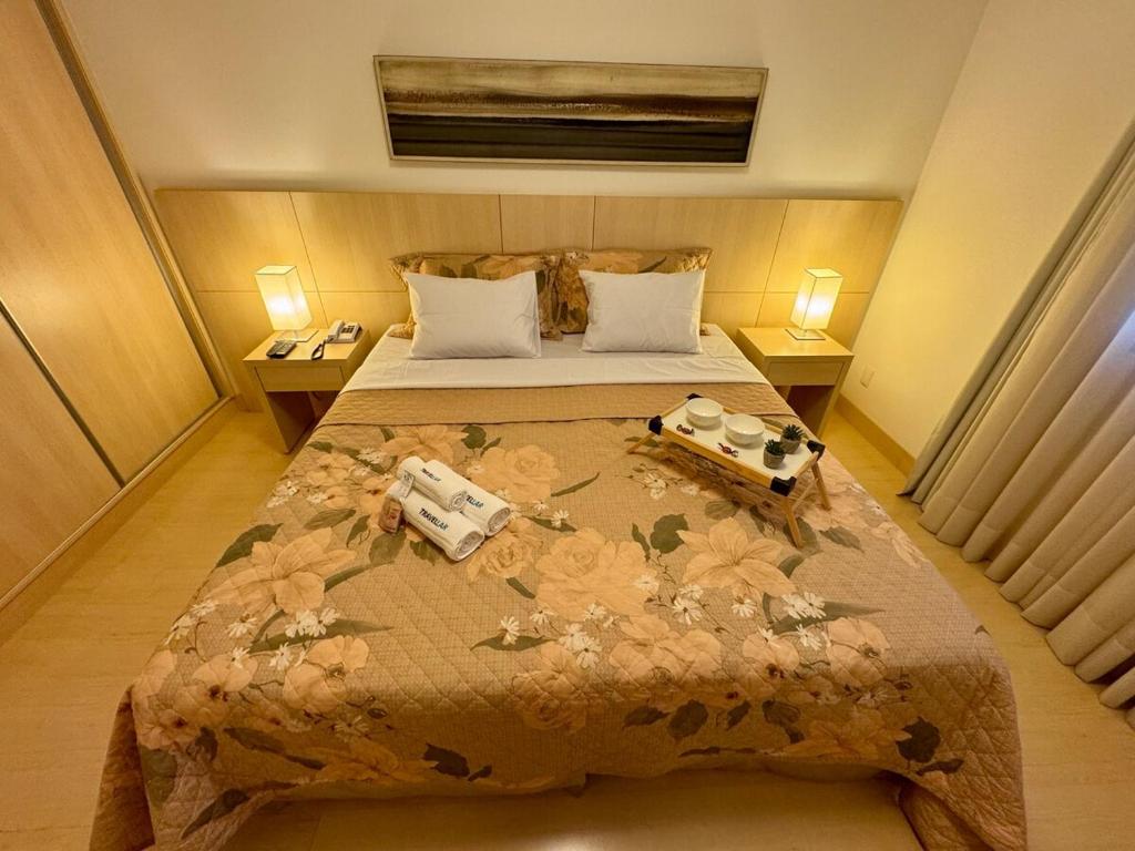 a bedroom with a bed with two cameras on it at Apto 601 Hotel Mont Blanc Premium in Ribeirão Preto