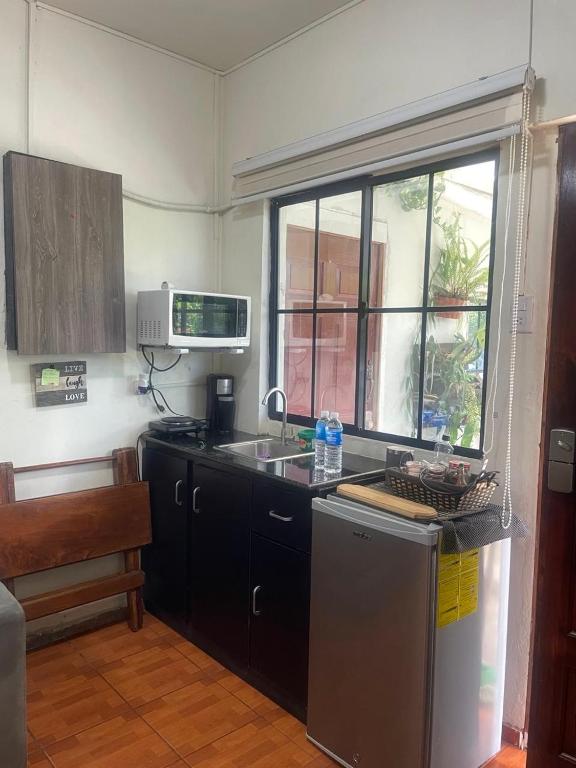 a kitchen with a sink and a dishwasher at Cuarto estudio HERSOR in San Salvador