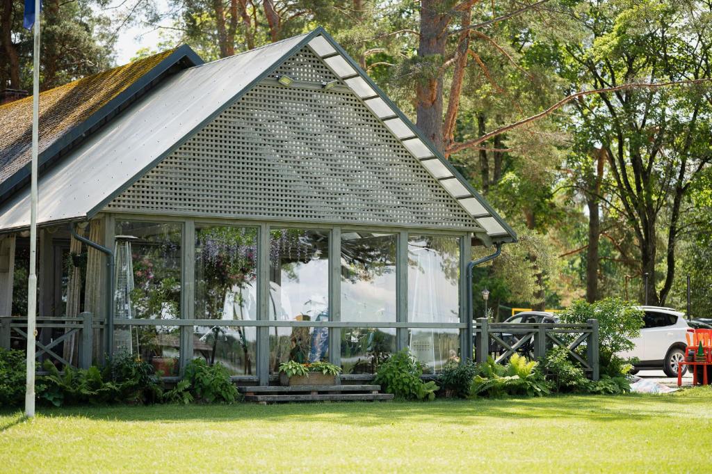 een klein gebouw met een dak en glas bij Atpūtas komplekss Usmas Meķi in Renda