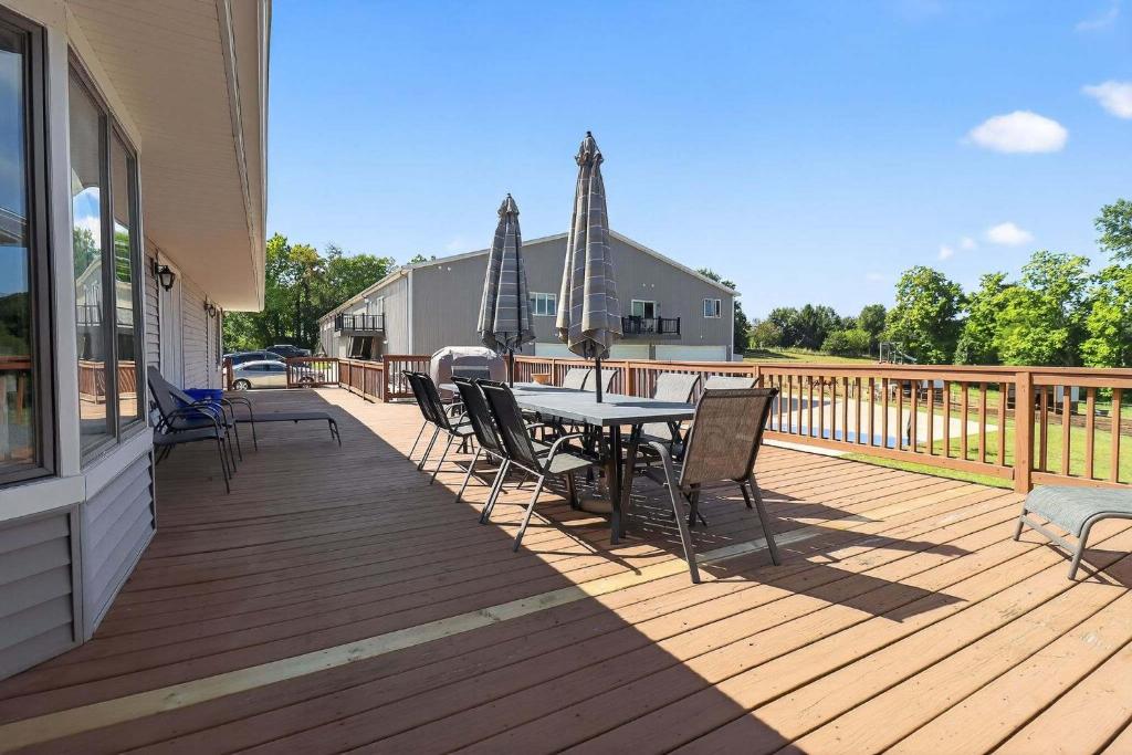 Un patio con una mesa y sillas en una terraza. en Grass Lake Retreat with Game Room & Fire Pit, en Grass Lake