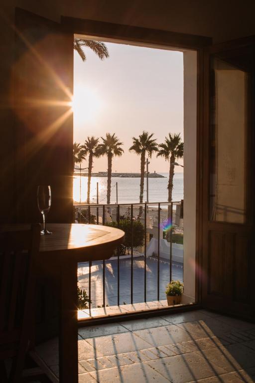 a room with a view of the ocean and palm trees at Antic Rooms Filador in Villajoyosa
