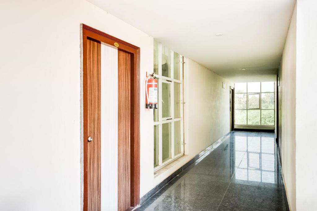 an empty hallway with a door and windows at Hotel O Ram Nivas in Kurmannapalem