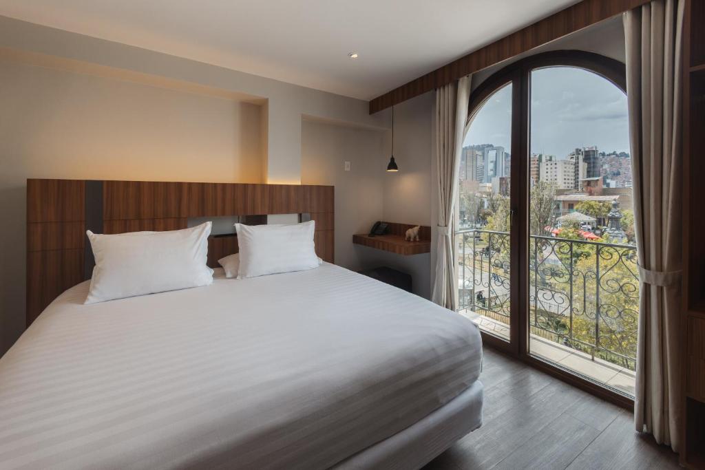 ein Schlafzimmer mit einem großen Bett und einem großen Fenster in der Unterkunft DREAM By Stannum Hotel in La Paz