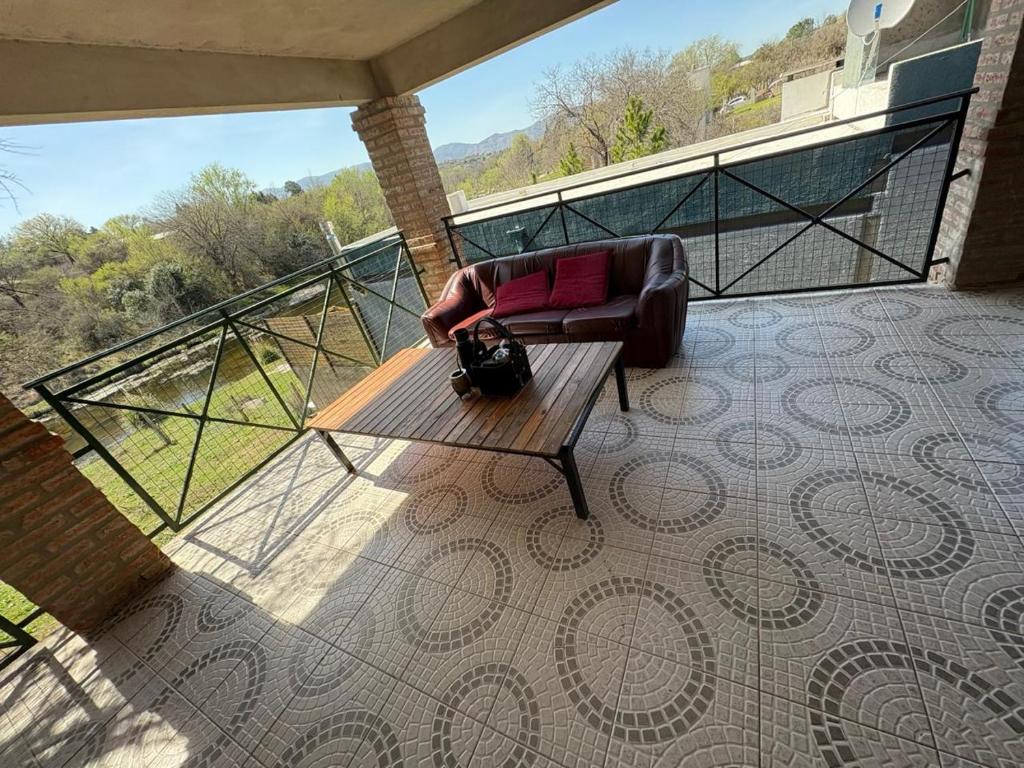 un balcon avec une chaise et un banc sur une terrasse dans l'établissement CASA EL GRINGO ubicada en Villa Parque Siquiman con vista al río tres habitaciones y capacidad para ocho personas, à Villa Parque Siquiman