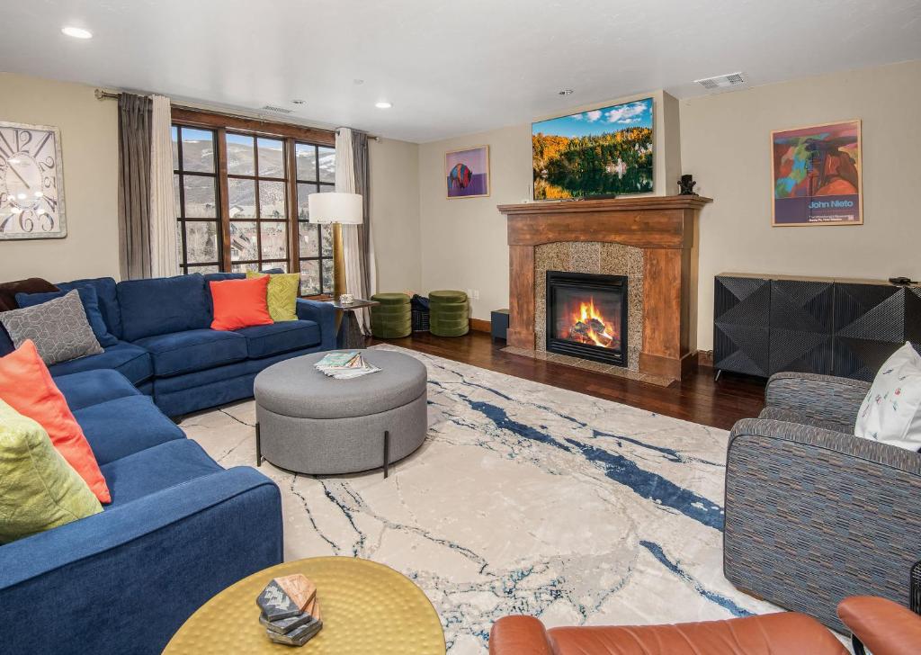 a living room with blue couches and a fireplace at Avon Ascent Retreat Indoor Pool Ski Shuttle in Avon