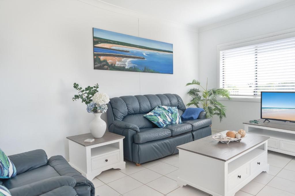 a living room with a couch and a tv at Sunrise on Terrace Unit 3, 21 Terrace Street Evans Head in Evans Head