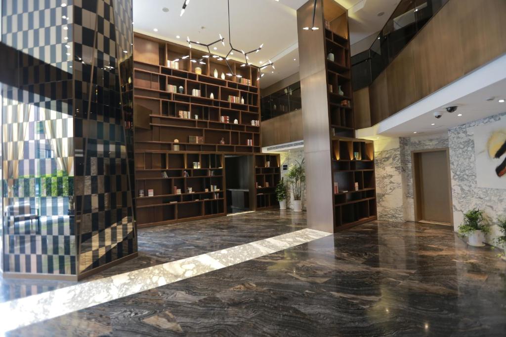 a lobby of a building with bookshelves at Green Court Residence Jinqiao Diamond Shanghai in Shanghai