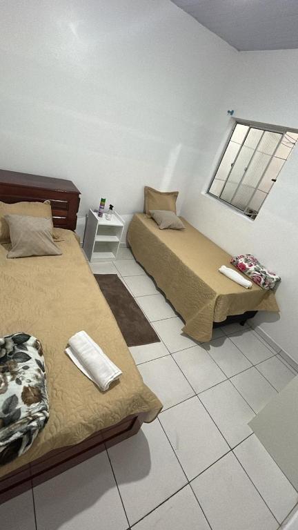 a room with two beds and a window at Pousada Ribeiro 2 in Belém
