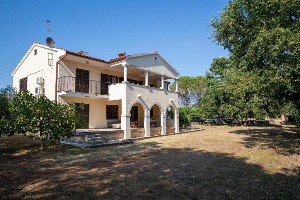 a large white house with a large yard at Apartments with parking space Sveti Lovrec, Central Istria - Sredisnja Istra - 24888 in Medaki