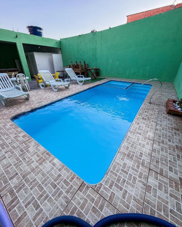 a large blue swimming pool on a tiled patio at Espaço laser soberana in Guarulhos