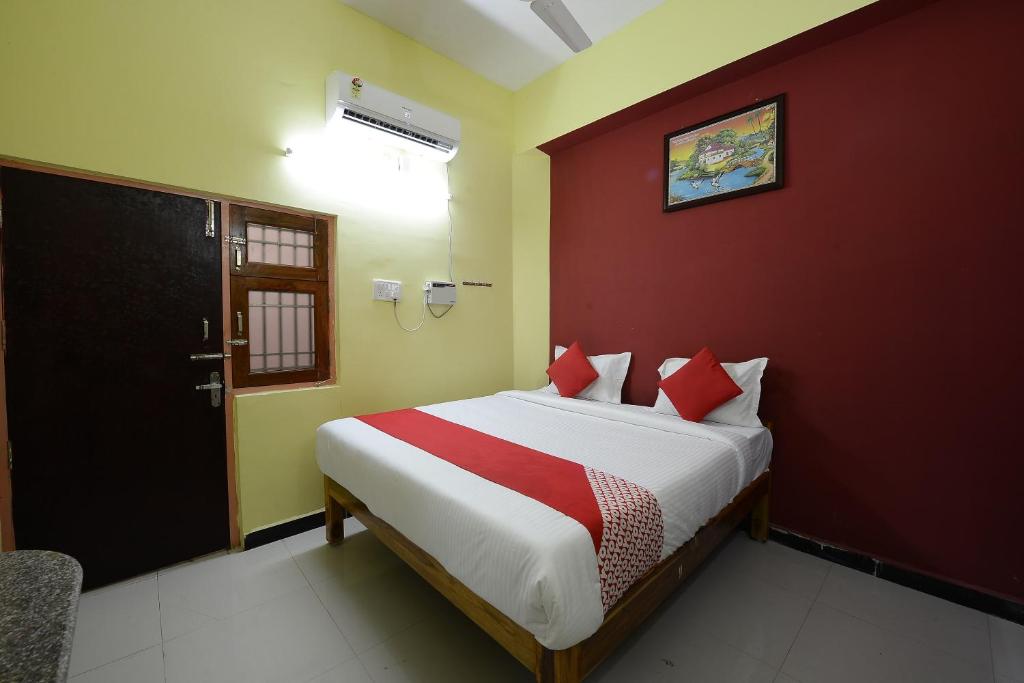 a bedroom with a bed with red and yellow walls at Super Hotel O Vellore New Bus Station Formerly SP Highway Inn in Vellore