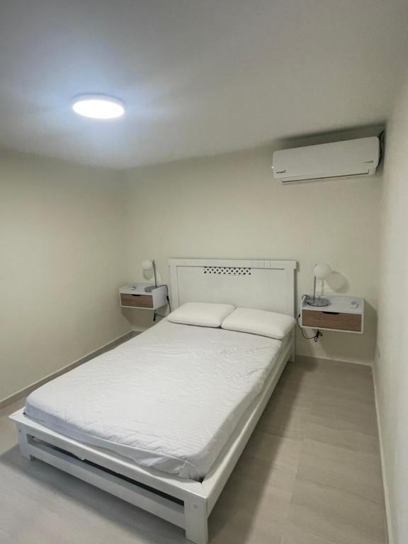 a small hospital room with a bed and a lamp at Comfortable apartment in Pereira