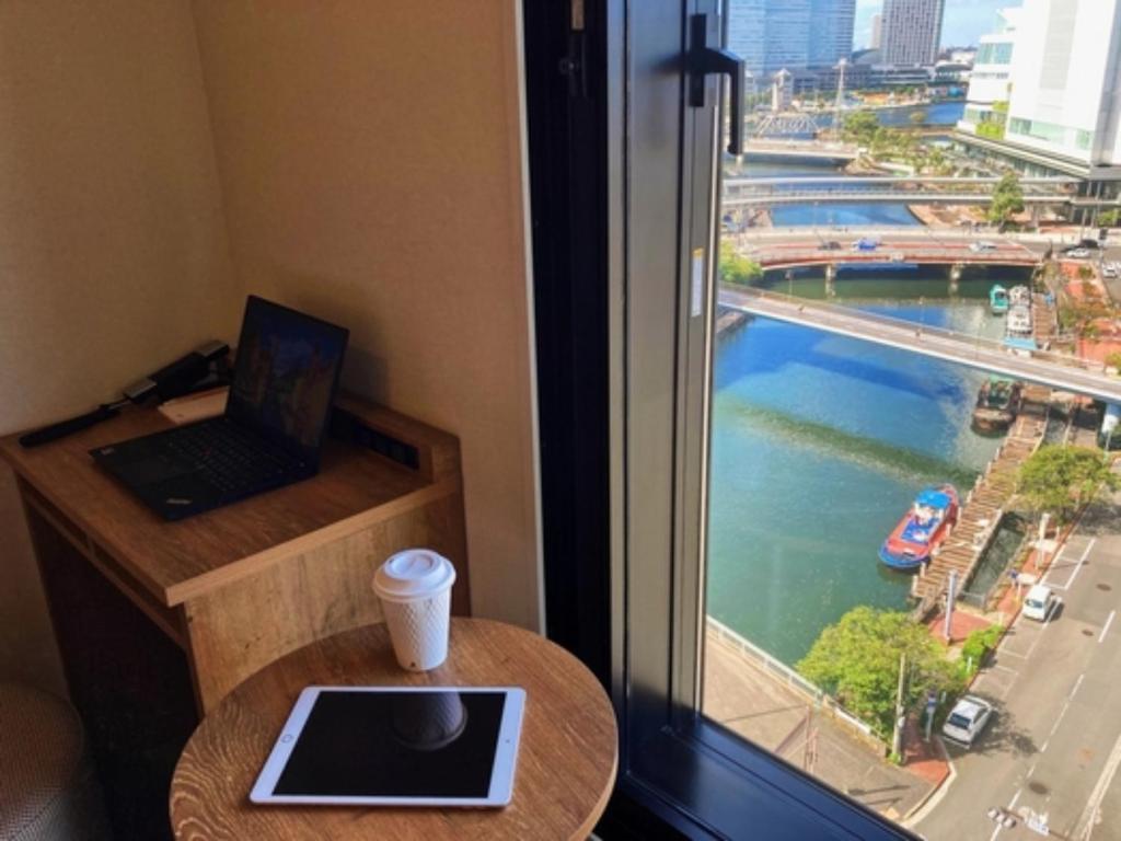 a room with a laptop on a table next to a window at Far East Village Hotel Yokohama - Vacation STAY 35243v in Yokohama
