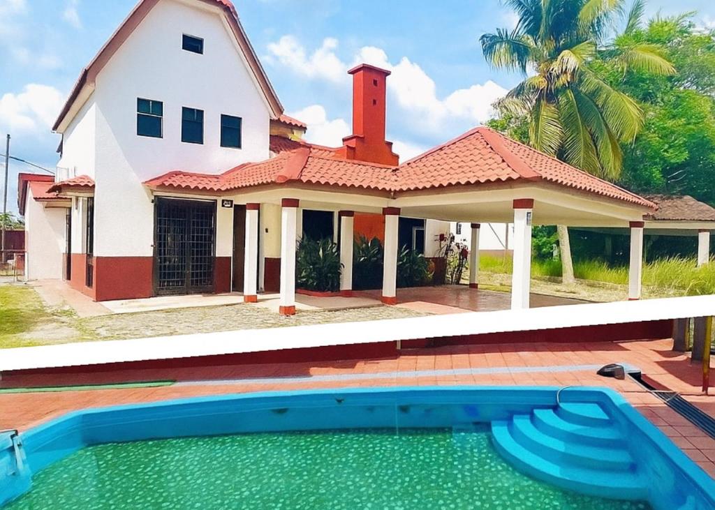 a house with a swimming pool in front of it at The 5R Famosa Villa in Kampong Ulu Pegoh