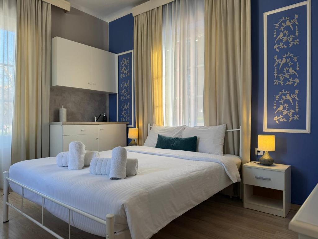 Un dormitorio con una cama grande con paredes azules. en Garden of Apollo, en Korinthos