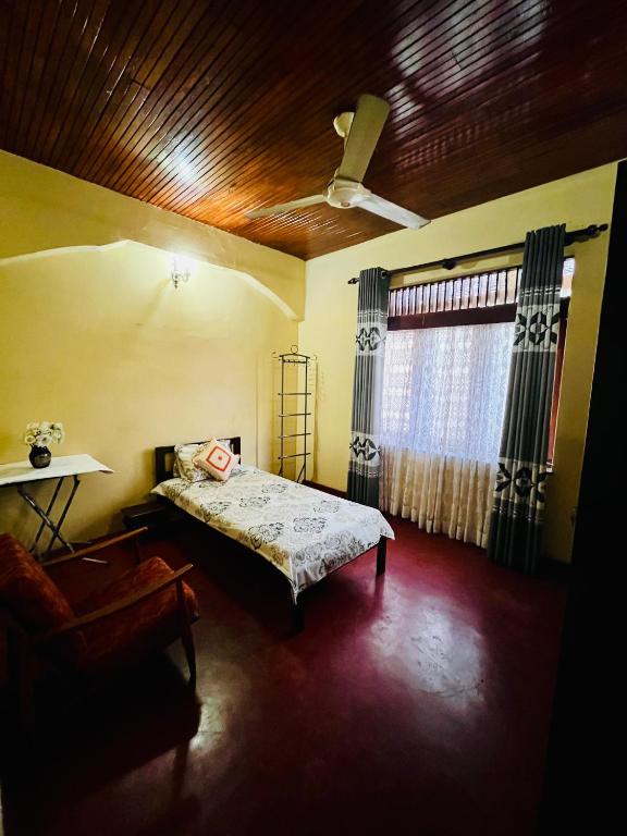 une chambre avec un lit, une chaise et une fenêtre dans l'établissement Peaceful Haven Cozy Retreat, à Nugegoda