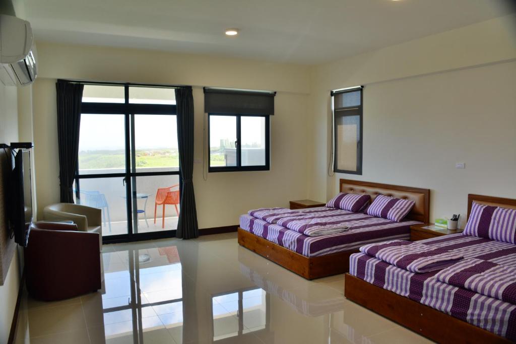 a bedroom with two beds and a balcony at Love Door 168 in Huxi