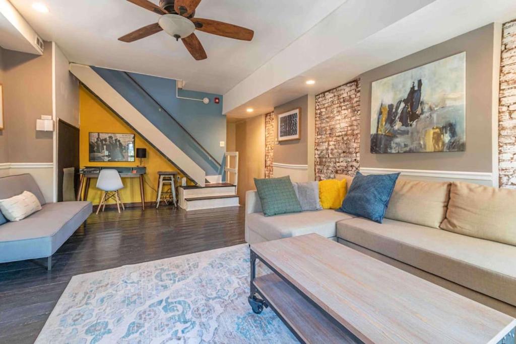 a living room with a couch and a ceiling fan at 1918 Duplex with Character City Center in Philadelphia