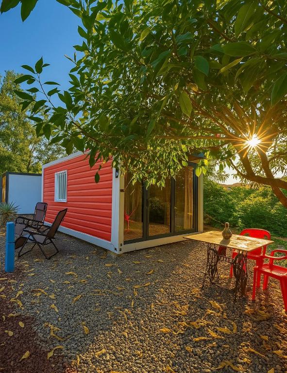 a red tiny house with a picnic table and chairs at Casa Terra cerca de Playa in Barra de Navidad