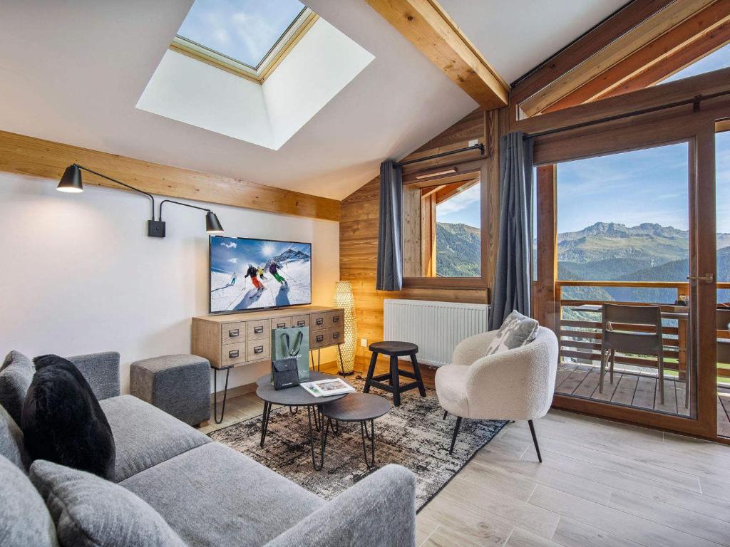 a living room with a couch and chairs and windows at Confort à Les Saisies, appartement pour 6 personnes avec parking - FR-1-809-28 in Les Saisies