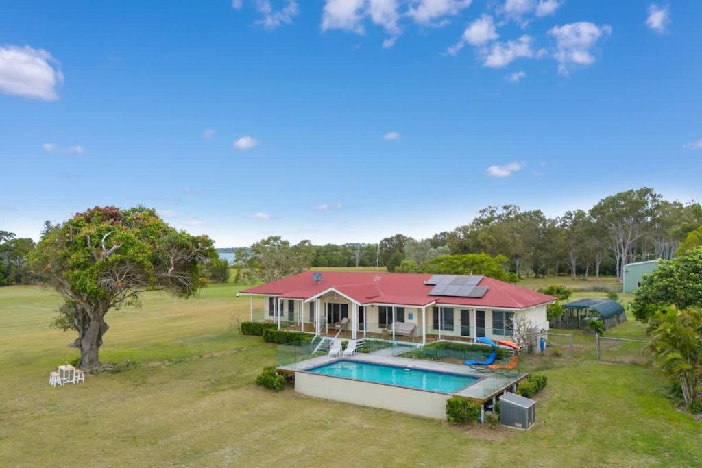 an aerial view of a house with a swimming pool at Beachfront Hervey Bay Homestead in River Heads