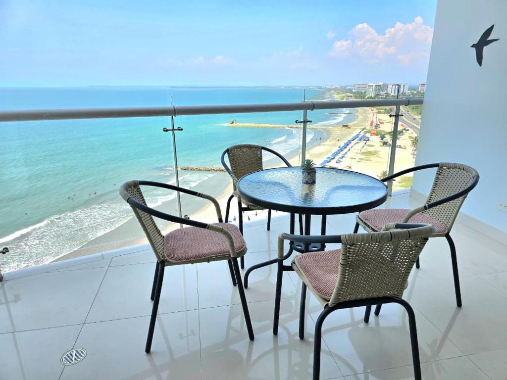 a table and chairs on a balcony with a view of the beach at Ikigai frente al mar con piscina infinita y Gym in Cartagena de Indias
