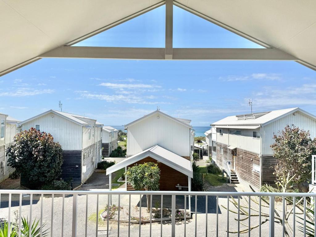a view of a row of houses from a balcony at Villa Oceania at Caves Beach Villas in Caves Beach