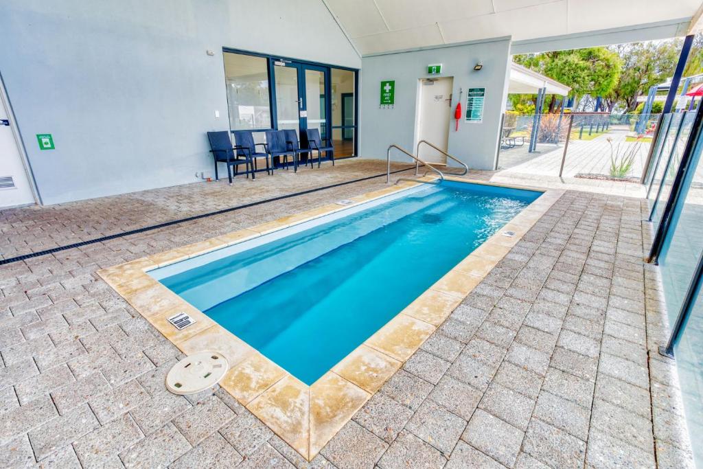 a swimming pool in front of a house at Tides at 65 Cape View Resort in Broadwater