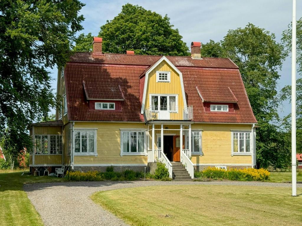 a large yellow house with a red roof at Historic Vicarage By The Lake In Dalskog in Dalskog