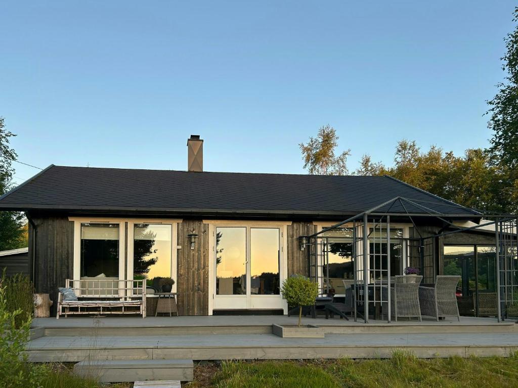 a small house with a porch with chairs on it at Cabin With Views Over Straumsundet in Øygarden
