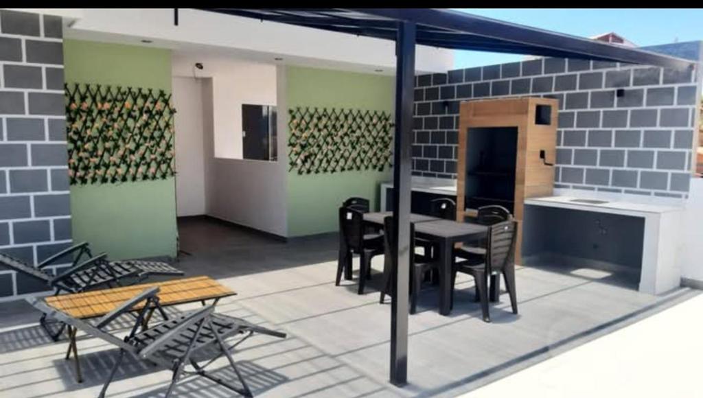 Un patio con una mesa y sillas en un edificio. en Huayrapata, en Sucre