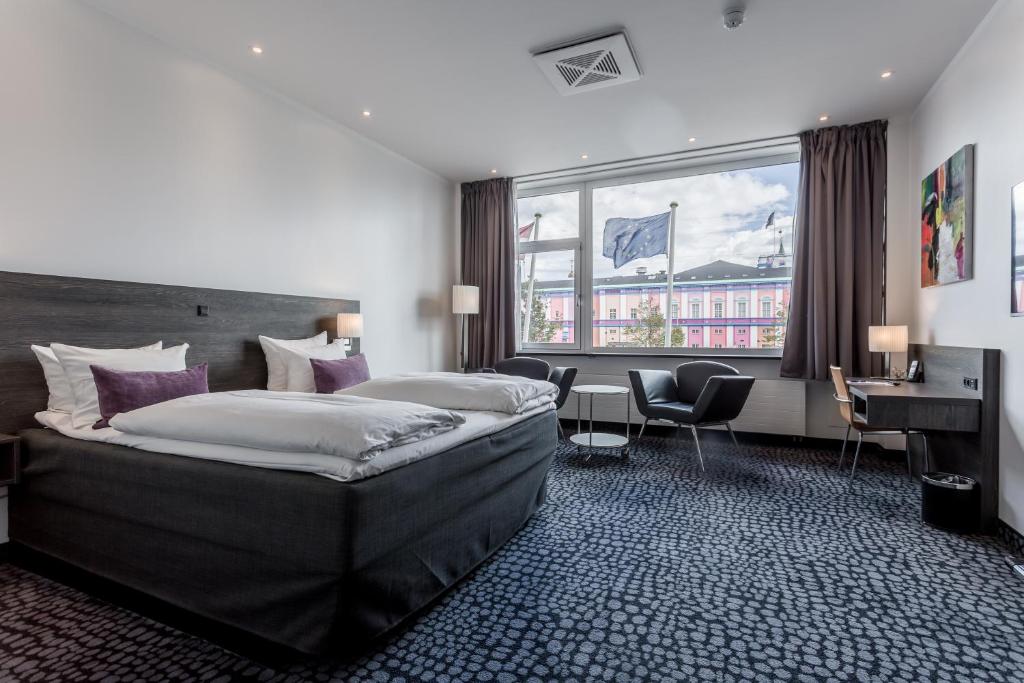 um quarto de hotel com uma cama grande e uma secretária em ProfilHotels Mercur em Copenhaga