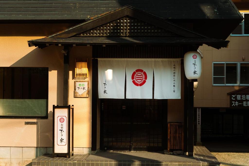 a building with a door with signs on it at Oyado Hisaya in Muraoka