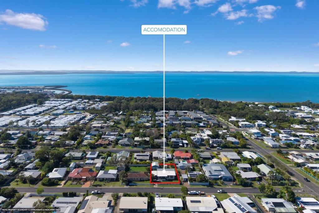 an aerial view of a suburb with the ocean in the background at Coastal Cottage in Urangan