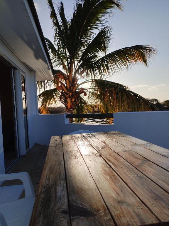 a wooden deck with a palm tree in the background at Lacaz Vacances in Tamarin