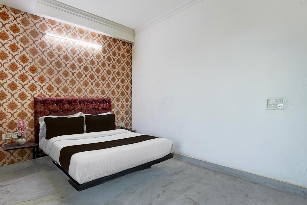 a bedroom with a bed and a wall at Townhouse Johri Enclave Metro Station Formerly Second Home in New Delhi