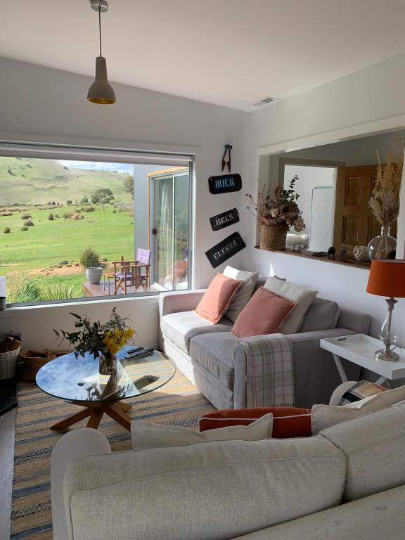 un salon avec un canapé et une table dans l'établissement Merino Cottage Meadowbank Lake, à Ellendale