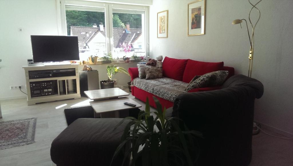 a living room with a red couch and a tv at Loft Nagoldtal in Pforzheim